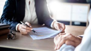 Attorney holding paperwork and a pen going over it with a client