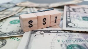 Wooden blocks that say SSI ontop of money